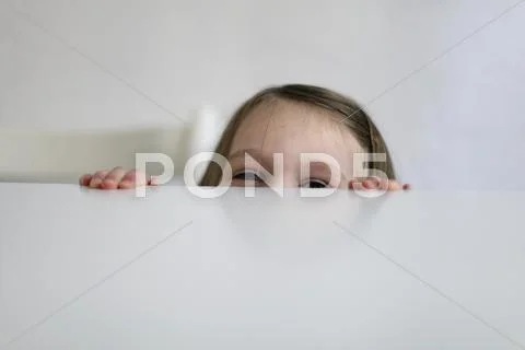Germany, Berlin, Girl hiding at table Stock Photos