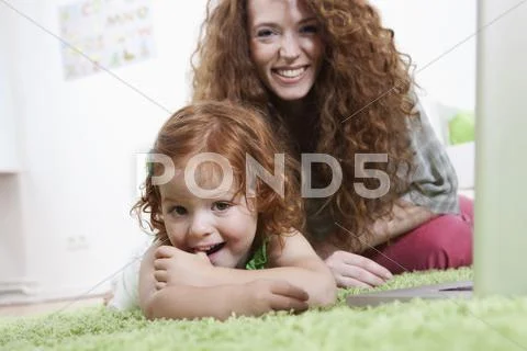 Germany, Berlin, Mother and daughter relaxing on floor Stock Photos
