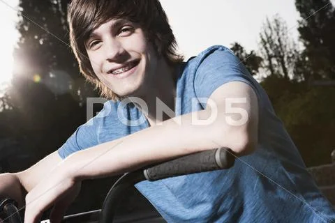 Germany, Berlin, Teenage boy on bike, smiling Stock Photos