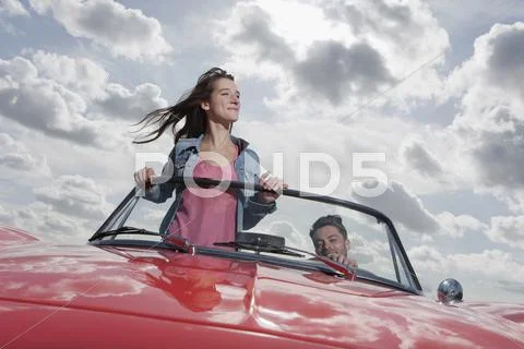 Germany, Berlin, Young couple driving in cabriolet Stock Photos