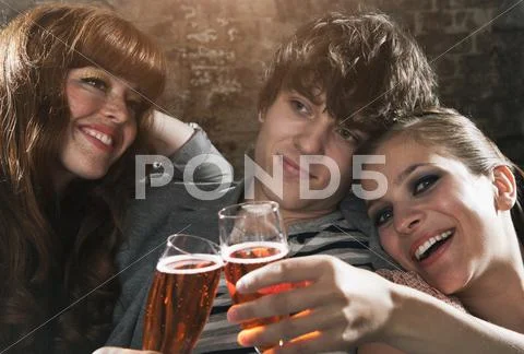 Germany, Berlin, Young man and women clinking champagne glasses, smiling Stock Photos