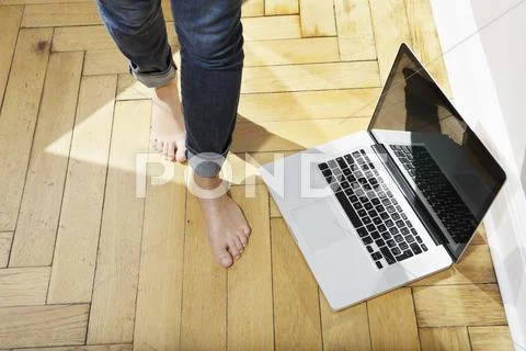 Germany, Berlin, Young woman feets walking by laptop Stock Photos