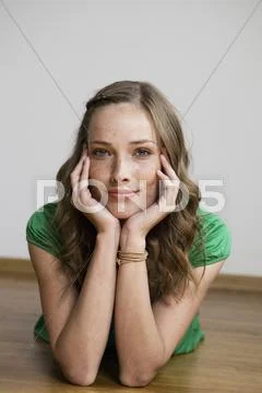 Germany, Berlin, Young woman lying on floor, portrait Stock Photos