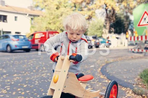 Germany, Bonn, Little boy with wood tricycle Stock Photos