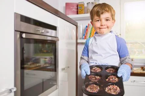 Germany, Boy baking cup cakes in tray, portrait Stock Photos