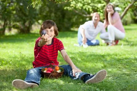 Germany, Boy holding easter eggs with parents in background Stock Photos