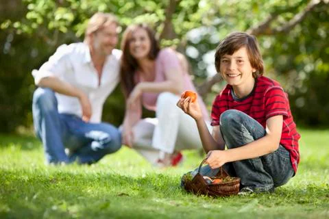 Germany, Boy holding easter eggs with parents in background Stock Photos