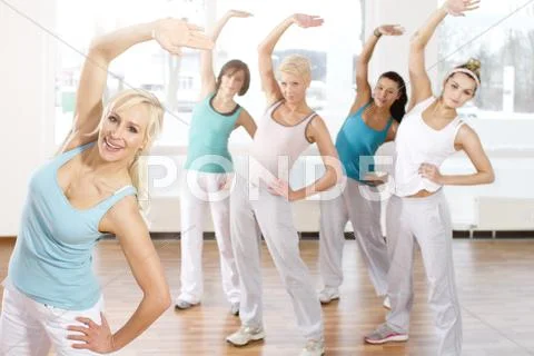 Germany, Brandenburg, Instructor and young woman doing exercise in gym Stock Photos