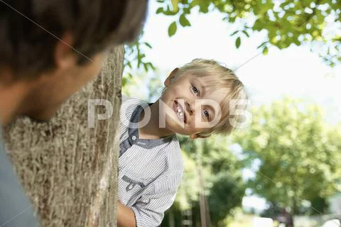 Germany, Cologne, Father and son playing head and seek, smiling Stock Photos