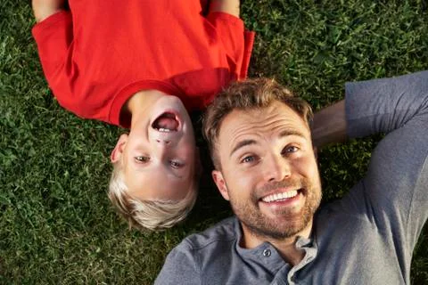Germany, cologne, father and son lying in meadow Stock Photos
