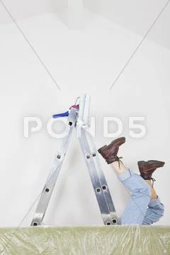 Germany, Cologne, Mature woman fallen down from step ladder during painting Stock Photos