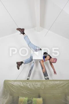 Germany, Cologne, Mature woman falling down from step ladder during painting Stock Photos