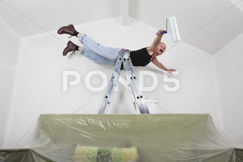 Germany, Cologne, Mature woman screaming while falling from ladder during Stock Photos