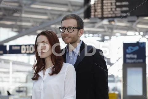 Germany, Cologne, Young woman and mid adult man at airport Stock Photos