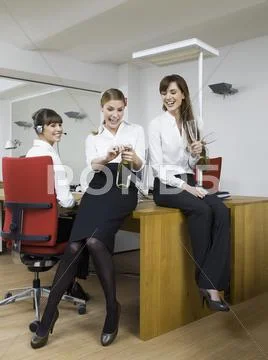 Germany, Cologne, Young women enjoying sparkling wine in office Stock Photos