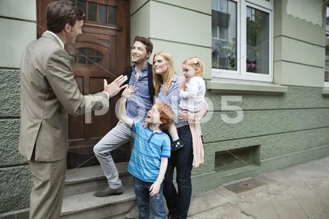 Germany, Duesseldorf, Boy giving high five to estate agent and family standing Stock Photos