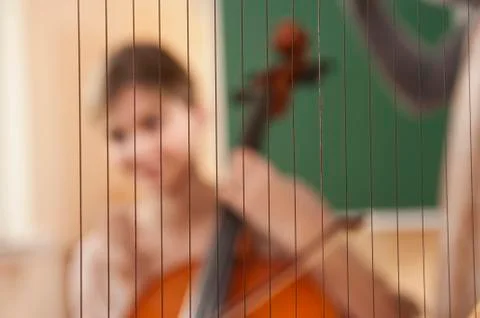 Germany, Emmering, Close up of harp with young woman playing musical instrument Stock Photos