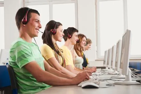 Germany, Emmering, Students using computer in computer lab, smiling Foto stock