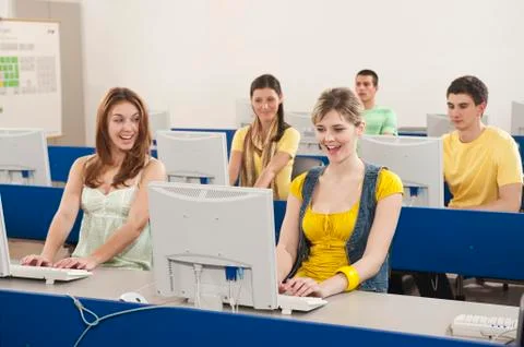 Germany, Emmering, Students using computer in computer lab, smiling Stock Photos
