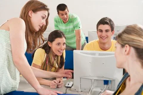 Germany, Emmering, Students using computer in computer lab, smiling Stock Photos