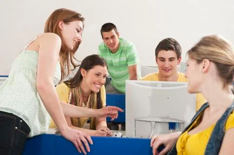 Germany, Emmering, Students using computer in computer lab, smiling Stock Photos
