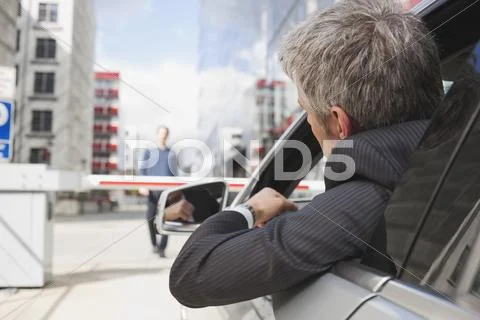Germany, Hamburg, Businessman sitting in car in front of closed barrier Stock Photos