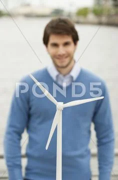 Germany, Hamburg, Close up of wind turbine, Businessman smiling in background Stock Photos