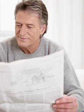 Germany, Hamburg, Senior man reading newspaper Stock Photos