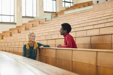 Germany, Leipzig, Students sitting face to face and talking in auditorium Stock Photos