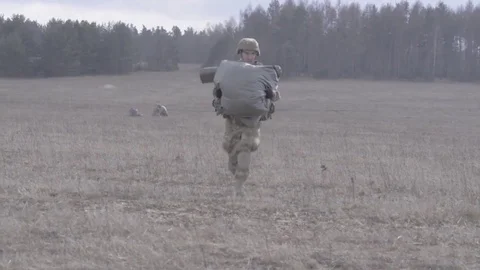 GERMANY, MARCH 2016, Soldier run with parachute over meadow. Stock Footage 72860754