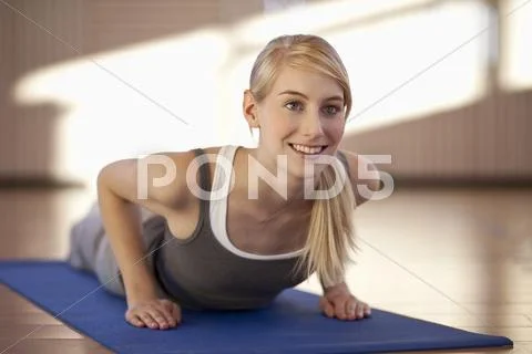 Germany, Mauern, Woman lying and exercising on exercise mat Stock Photos