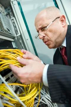 Germany, Munich, Business man checks connectivity on a computer server rack Stock Photos