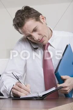 Germany, Munich, business man in office using mobile phone Stock Photos