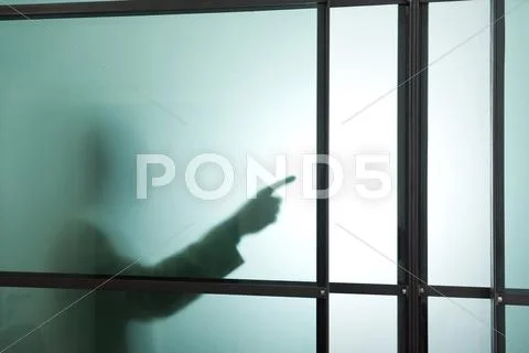 Germany, Munich, Silhouette of businessman behind frosted glass, gesturing Stock Photos
