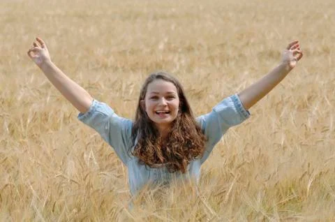 Germany, Munich, Teenage girl with arms up in cornfield Stock Photos