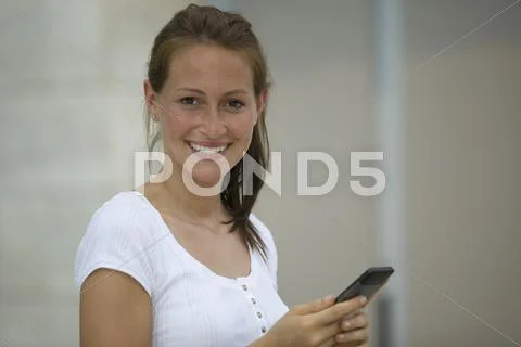 Germany, North Rhine Westphalia, Cologne, Young woman using smart phone, Stock-Fotos