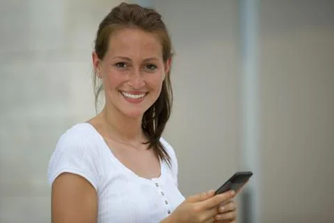 Germany, North Rhine Westphalia, Cologne, Young woman using smart phone, Stock Photos