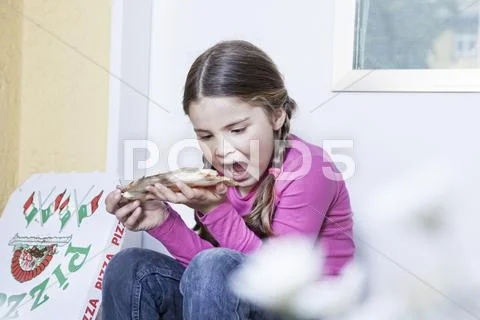 Germany, north rhine westphalia, cologne, girl eating pizza Stock Photos