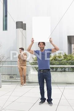 Germany, North Rhine Westphalia, Duesseldorf, Trainee with shield, man using Stock Photos
