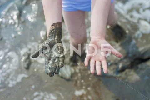 Germany, Schleswig Holstein, Boy Playing In Mud At Beach