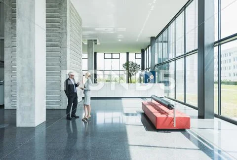 Germany, Stuttgart, Business people having discussion at office lobby Stock Photos