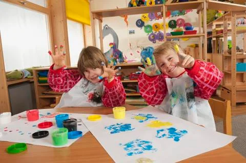 Germany, Two boys (3-4), (6-7) fingerpainting in nursery, showing hands, Stock Photos