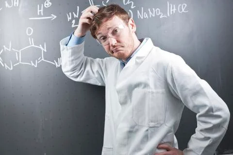 Germany, Young scientist with pluzzled facial expression and chemical equation Stock Photos