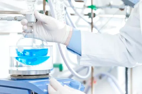 Germany, Young scientist setting up experiment with flask and condenser Stock Photos