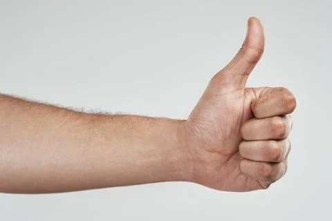 Gesture, hand and thumbs up in studio for agreement, support sign or well d.. Stock Photos