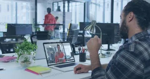 Gesturing bearded man in dark plaid shirt watching laptop at office, with Foto stock