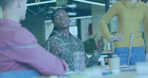 Gesturing Black developer wearing green plaid shirt presenting at tech office Stock Photos