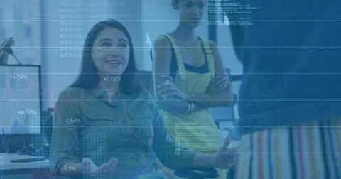 Gesturing developer in green shirt sitting at open office, with computer 写真素材