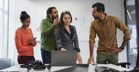 Gesturing lead in grey blazer directing discussion at meeting room, with laptop Stock Photos