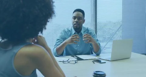 Gesturing manager wearing light blue shirt speaking at office meeting table,  库存照片